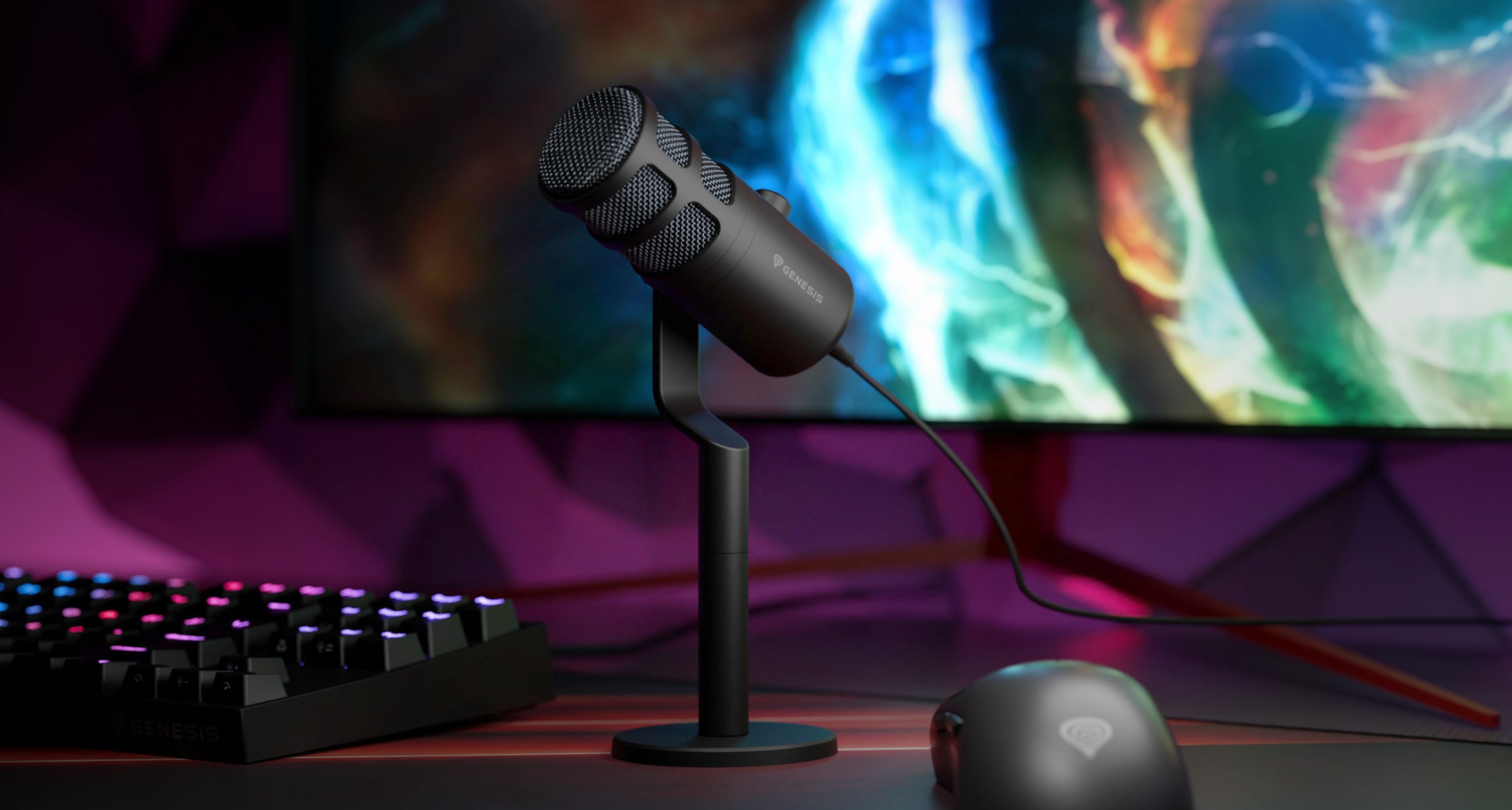 Dynamický mikrofon USB na stojanu, s barevným pozadím a herní klávesnicí a myší poblíž.