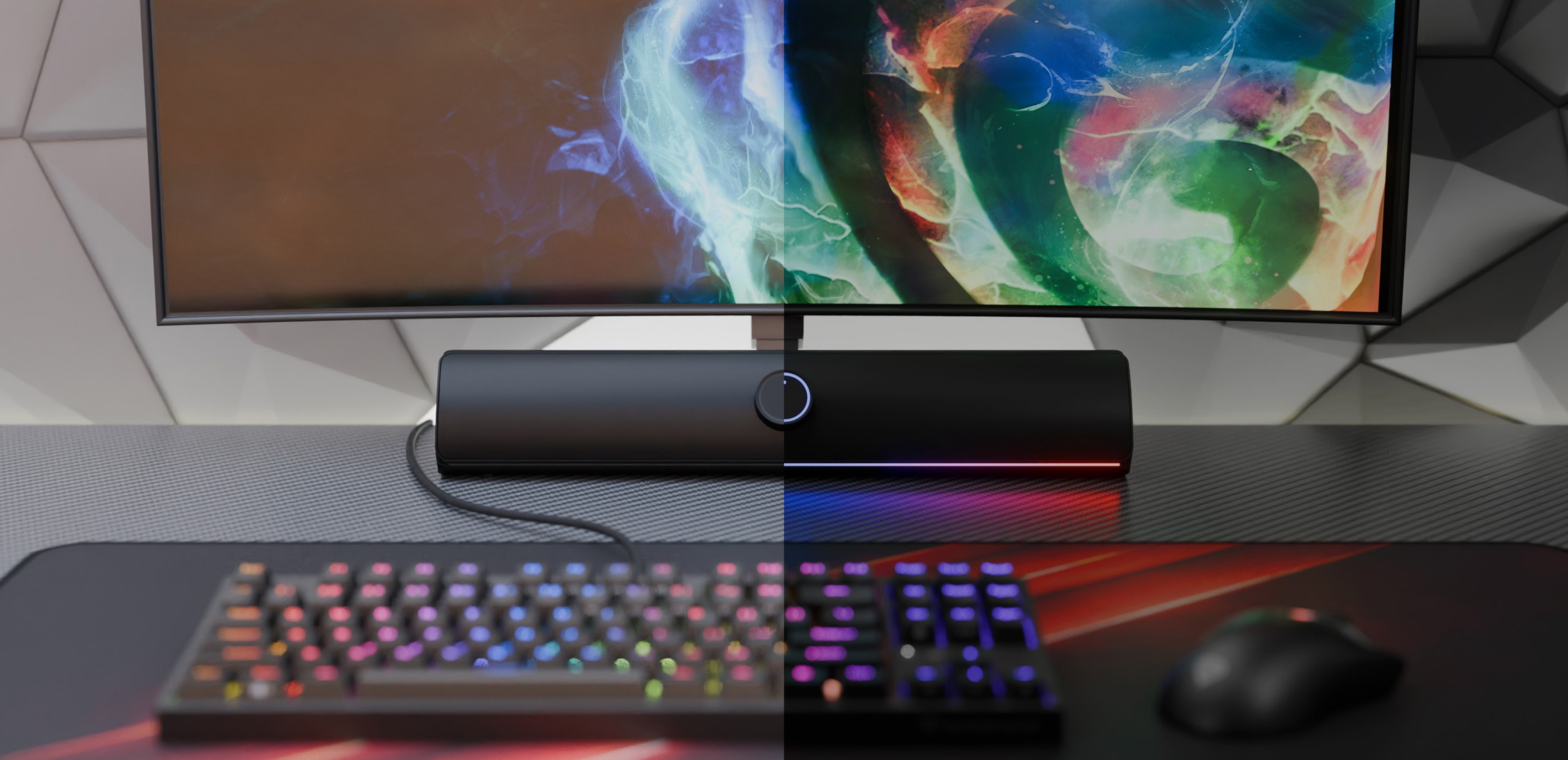 Černý soundbar Bluetooth umístěný pod barevným monitorem s herní klávesnicí a myší RGB na stole