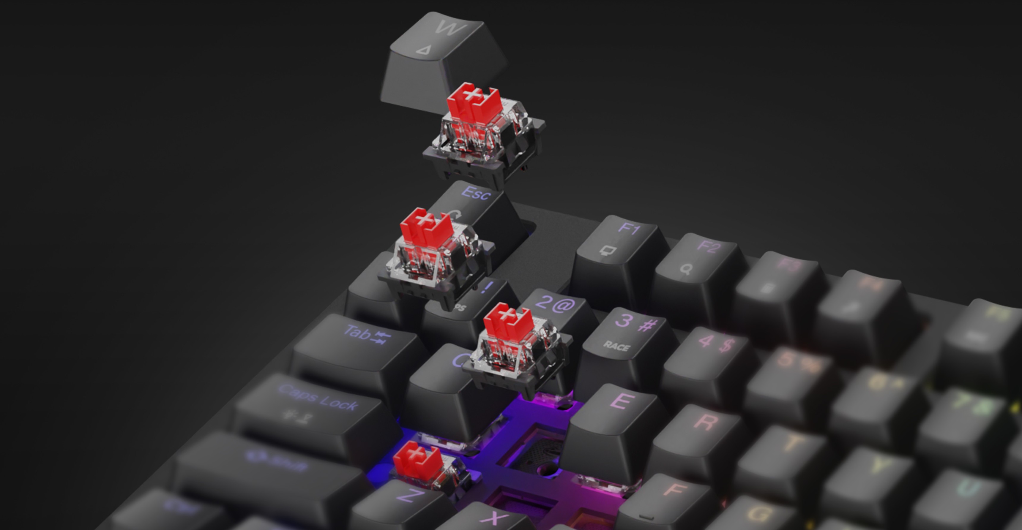 Mechanická herní klávesnice s červenými spínači a duhovým RGB osvětlením, která předvádí za chodu vyměnitelné klávesy a spínače